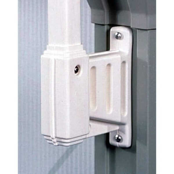 Close-up of a Fixed Post Bracket in white, securely mounted on a wall with screws to hold a vertical pole. The background features both a textured surface and a smooth gray structure.