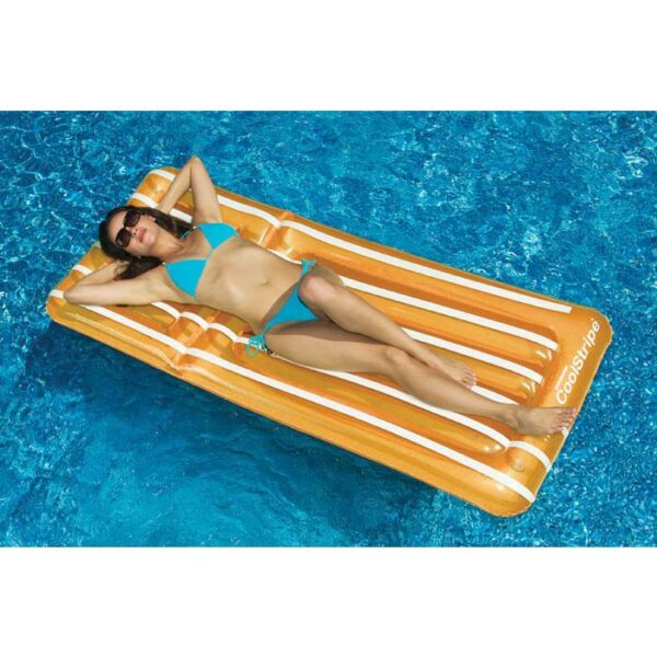 A woman in a blue bikini and sunglasses relaxes on a Cool Stripe Matress, floating on clear blue water.