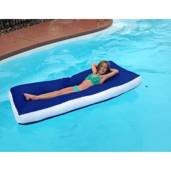 A young girl in a green swimsuit relaxes on the Aqua Cloud - Sky blue and white pool float, lying on her back with her hands behind her head in a swimming pool.