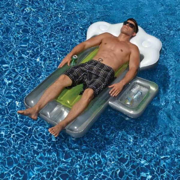 A man in sunglasses and swim trunks relaxes on a Beer Mug Float with built-in drink holders, drifting on clear blue water.