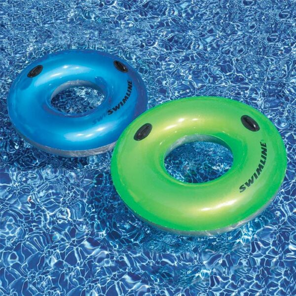 Two SUNTANNER STYLE RING 36IN inflatable pool tubes, one blue and one green, float on the clear, sunlit water.