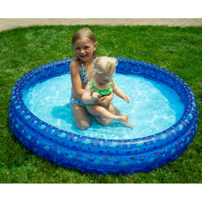Two young children play in the 60IN 3 RING INFLATABLE POOL on green grass. The older child smiles at the camera while holding the younger one, who sits in the shallow water of the blue pool.