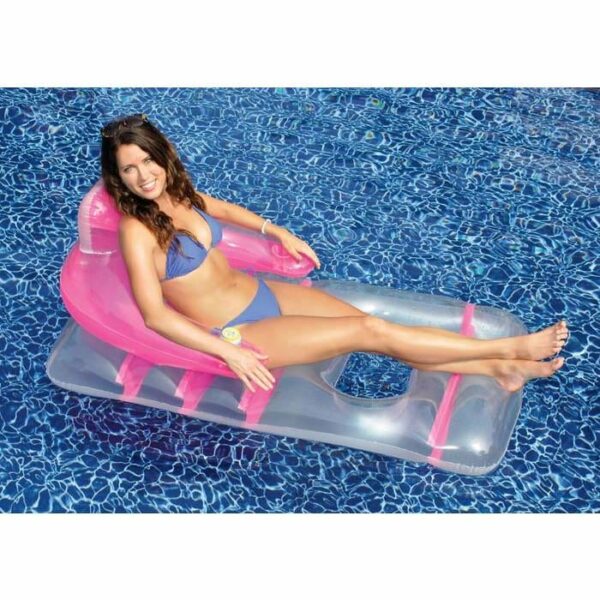 A woman in a blue bikini relaxes on the Deluxe Lounge Chair, a transparent and pink inflatable, as she floats in a clear blue swimming pool, smiling and enjoying the sunny day.