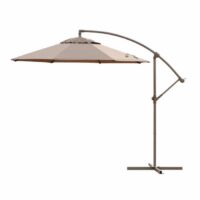 The 9 Octagon Cantilever - Toffee is a large beige patio umbrella with a curved metal stand and cross-shaped base, offering outdoor shade without a central pole underneath.