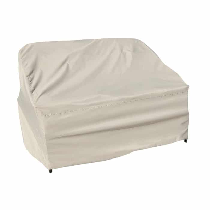 The Cover: Wicker Loveseat is a beige outdoor cover that fits smoothly over a loveseat, with slight wrinkles and visible seams, providing full protection from the elements.