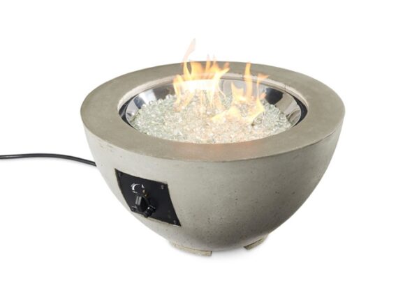 The Cove Gas Firepit Bowl 20 features a round concrete exterior, clear fire glass, a vibrant orange flame, and is equipped with a side control knob and power cord.