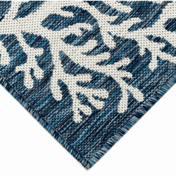 Close-up of the Outdoor Rug-Coral Border Navy, showing a white coral border pattern on a textured navy blue surface with visible woven threads and fringed edges.