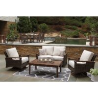 The outdoor patio showcases the Paradise Trail Grouping (3 pc) wicker seating set—sofa and two armchairs with a wooden coffee table on a patterned rug. A pool and dining area are in the background, framed by lush greenery.