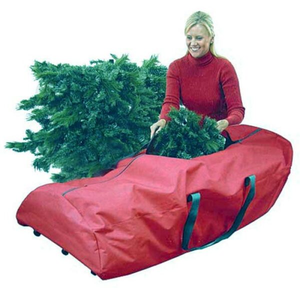 A woman in a red sweater places sections of an artificial Christmas tree into the Rolling Tree Bag 9FT, a large red storage bag with black handles.