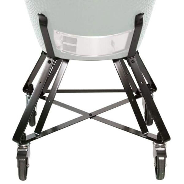 A close-up of the Nest for Large Big Green Egg shows its sturdy black metal legs, crossbars for stability, and four caster wheels supporting a large, round grill.