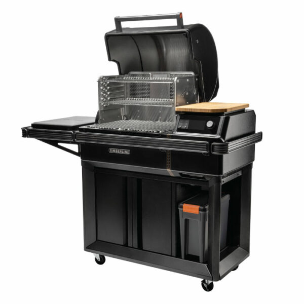 The Timberline 2022 is a black, wheeled outdoor grill featuring a hinged lid, metal grilling rack, wooden cutting board on the side shelf, plus a storage compartment and trash bin underneath.