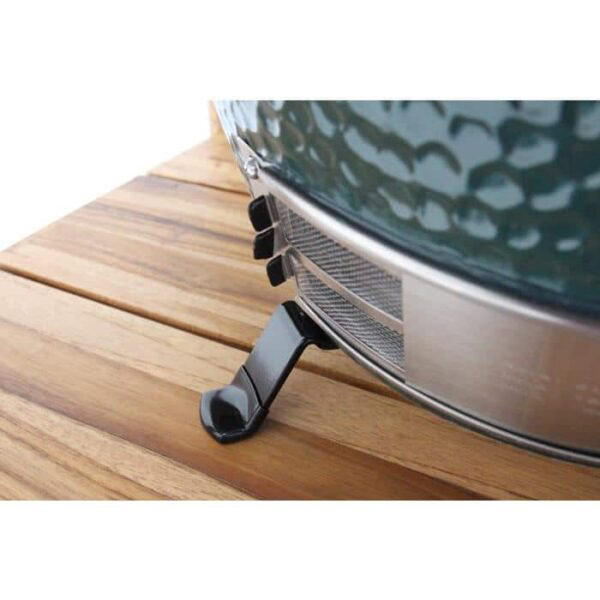 Close-up of the Table Nest for Large EGG, supporting a green ceramic grill or smoker on a wooden surface, with the bottom vent visible.