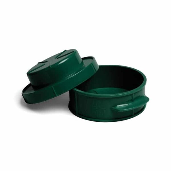 A dark green, round plastic Stuff-A-Burger Press with a matching lid, slightly tilted open to reveal the empty interior. The press features small side handles.