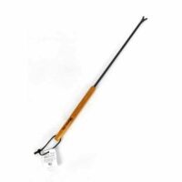 The Big Green Egg Grid Cleaner features a long handle with a wooden grip and a black metal shaft ending in a small, claw-like cleaning tip. A tag is attached to the handle.