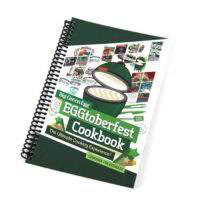 The spiral-bound EGGtobergect Cookbook features a grill illustration on the cover, small images of dishes, and the tagline The Ultimate Cooking Experience.