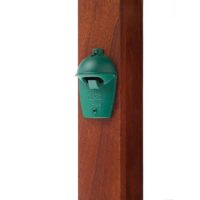 A Big Green Egg Shaped Bottle Opener is mounted on a vertical wooden post.