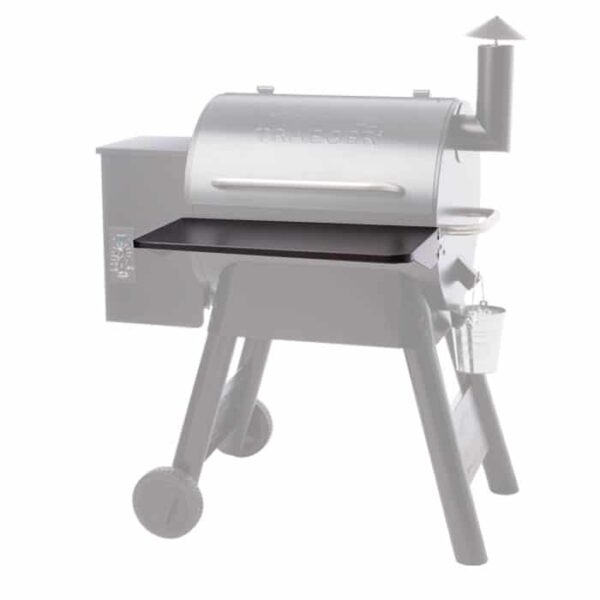 The TRAEGER Folding Front Shelf-22 Series, shown here in black, is attached to the front of a gray pellet grill to highlight this useful shelf accessory.