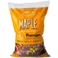 A bag of TRAEGER-Maple Pellets, with yellow and orange packaging, bold lettering, and an image of grilled meat garnished with herbs at the bottom.