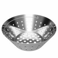 The BGE-L Stainless Fire Bowl, made of shiny stainless steel with a round shape and multiple holes for draining, is shown from an angle revealing the interior and part of the rim.