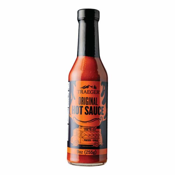 A bottle of Traeger Original Hot Sauce with a black cap and an orange and black label with flames, a grill, and “9 oz (255g)” at the bottom.