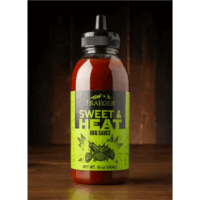A bottle of TRAEGER-Sweet & Heat 16 OZ Sqz with a green label and black squeeze top rests on wood, set against a dark wood background. The bottle contains 16 oz (454g) of sauce.