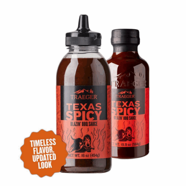 Two bottles of TRAEGER-Texas Spicy 16 OZ Sqz BBQ sauce with red and black labels featuring a flame and bear. An orange badge reads, “Timeless flavor, updated look.”.