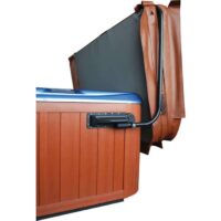 The Covermate I ECO cover lifter is mounted on the side of a brown wooden hot tub, holding the brown folded cover upright to make removing the cover easier.