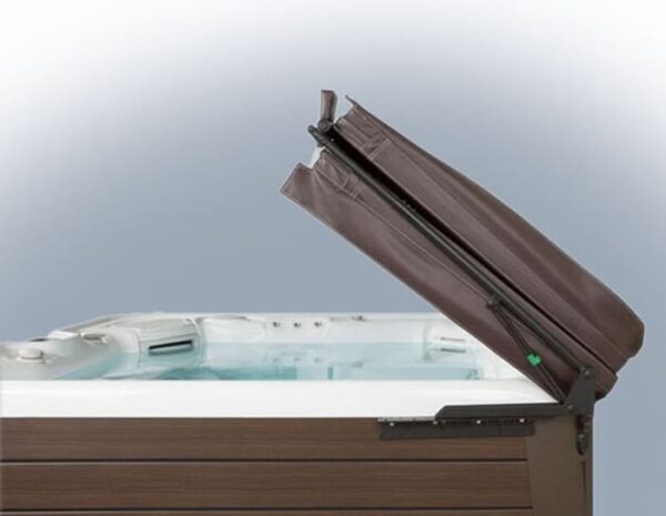 A brown hot tub with clear water is shown with its lid partially lifted and propped open by the Cover Lifter: Cover Valet Pro, against a plain gradient background from white to light blue.