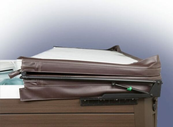 The Cover Valet Pro cover lifter holds a brown hot tub cover partially folded back, exposing the edge of the hot tub. Its sturdy metal mechanism attaches to the side of the tub for easy lifting and support.