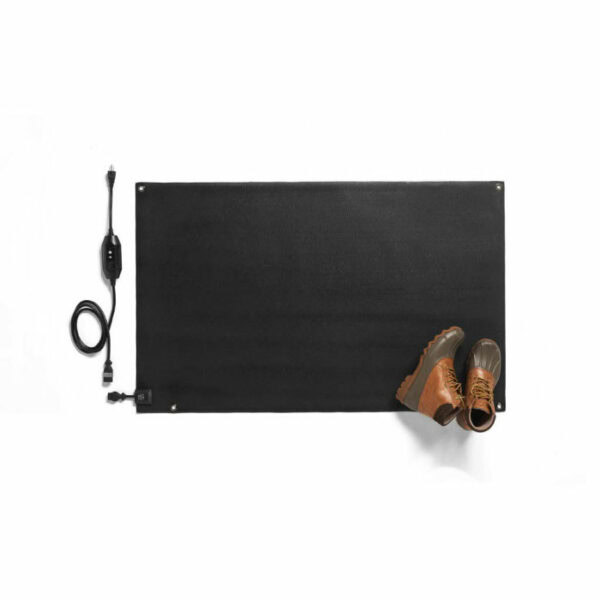 The HeatTrak Heated Snow Melting Entrance Mat (Medium, 30 x 48) is pictured in black with a power cord and control switch on a white background. Brown boots rest on the bottom right corner of the mat.