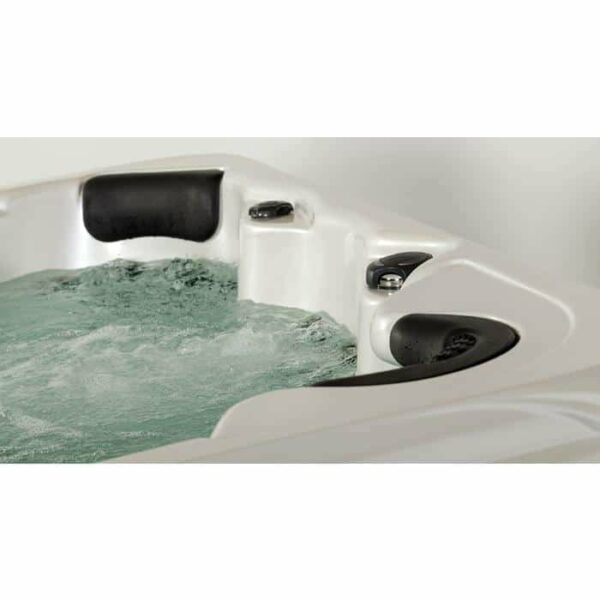 Close-up of the Lanai hot tub with a Midnight Canyon shell and black cabinet, featuring bubbling water, black headrests, and control knobs on the edge.
