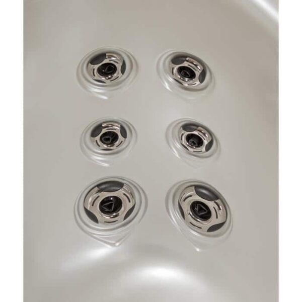 Close-up of six shiny, circular metal jets in two rows inside the smooth, white Lanai - Midnight Canyon Shell/Black Cabinet hot tub surface.