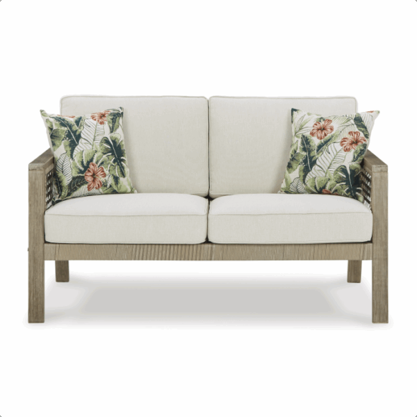 The Barn Cove Grouping 4-piece is a beige outdoor sofa with a wooden frame, two seat cushions, two back cushions, and two decorative pillows featuring green and orange tropical leaf and flower patterns.