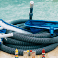 Prepare your pool for the season with the Above Ground Pool Closing 2025 kit, featuring a coiled hose, brush, net, and water test kits with colored bottles neatly arranged by your poolside.