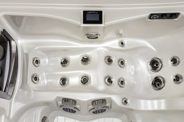 Close-up view of the inside of the Dove Canyon with Stereo hot tub in a White Pearl Shell/Smoke Cabinet, highlighting multiple water jets, a small control panel, and sleek seating contours.