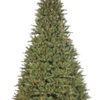 The 6.5 Fairhaven Spruce with Clear Lights StayLit is a full artificial Christmas tree with dense green branches, pre-lit with warm white lights, and set on a metal stand against a plain white background.