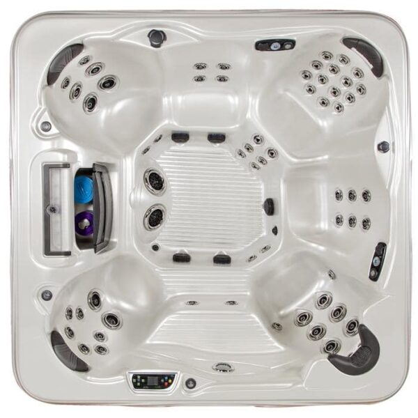 Top-down view of the Grand Cayman Elite hot tub in Glacier Mountain Shell with a Grey Cabinet, featuring five contoured seats, multiple water jets, a digital control panel, and a built-in compartment holding a blue towel and two purple bottles.