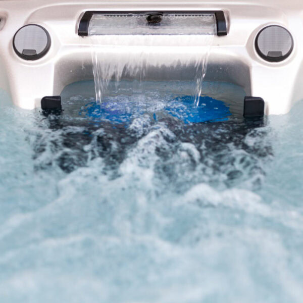 Close-up of bubbling water in the TAHITI Glacier Mountain Shell/Black Cabinet hot tub, featuring a small waterfall and two circular jets at the back.