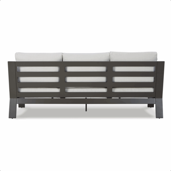 The Tropicava Grouping 4-piece features a modern outdoor sofa with a dark metal frame, horizontal slats, and three light-colored cushions shown from the back view.