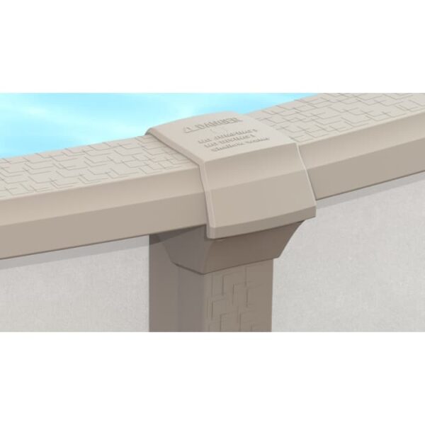 Close-up of the beige edge and vertical support post of the 15 x 54 Milan Pool Package above-ground pool, showing its textured pattern, warning label, and water in the background.
