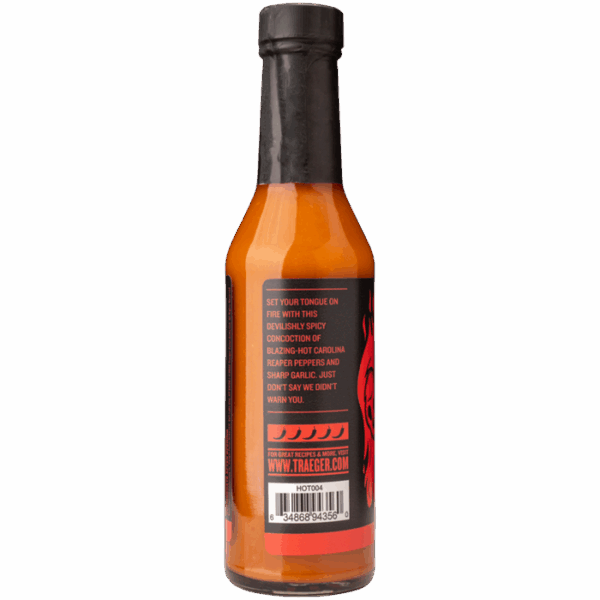 A bottle of Traeger Carolina Reaper & Garlic Hot Sauce with a black cap and label features a spicy blend with Carolina Reaper peppers, includes an extreme heat warning, and displays a barcode at the bottom.